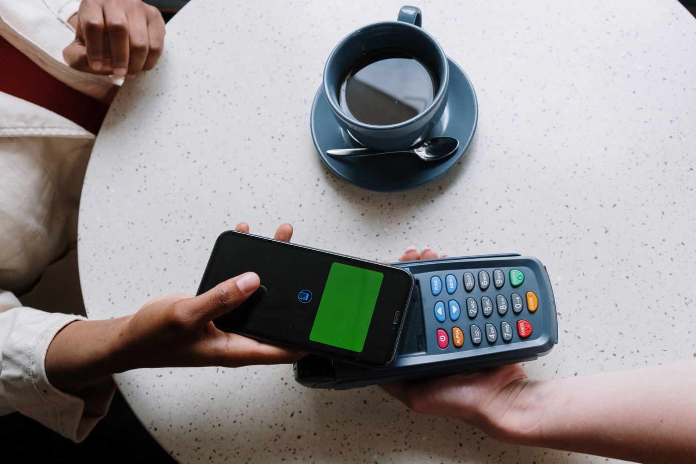 A contactless card tapping a smartphone for payment